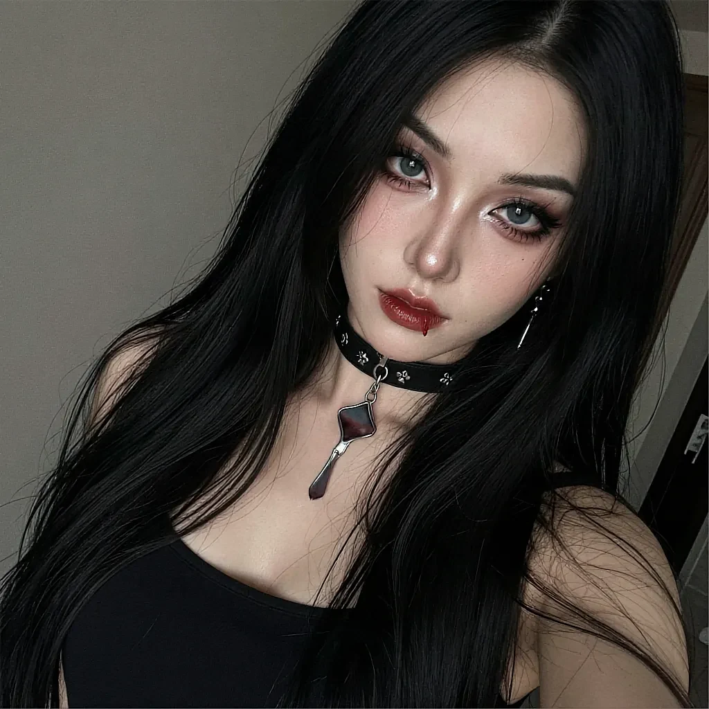 Long black-haired woman with pale skin and green eyes wearing a studded leather choker with a pendant